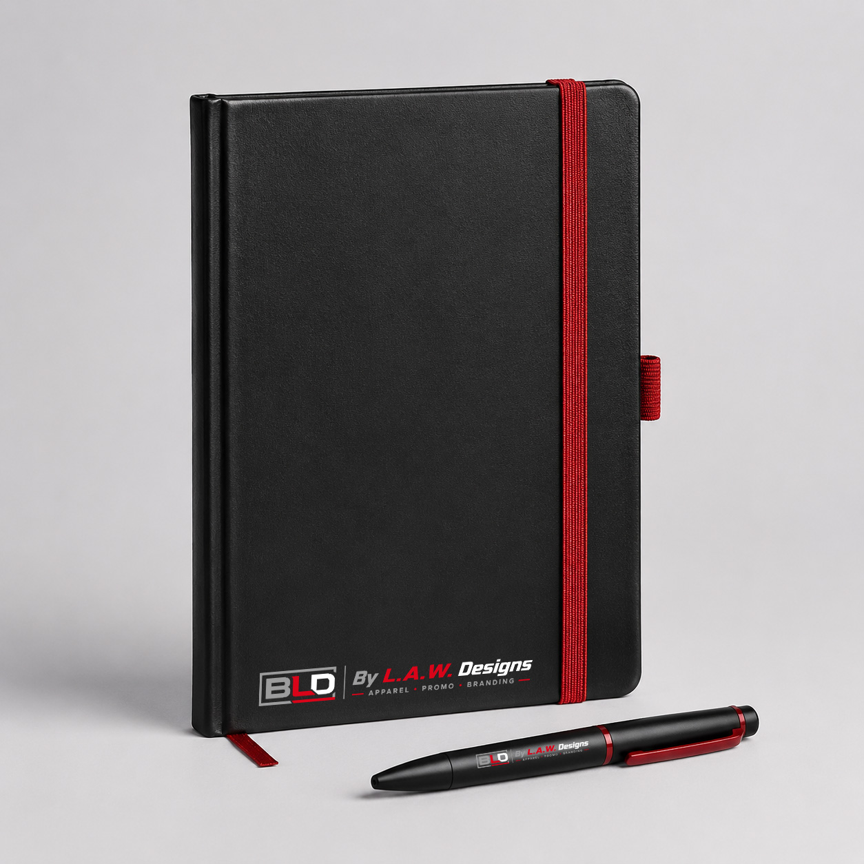 Black promotional notebook and pen decorated with the official BLD logo